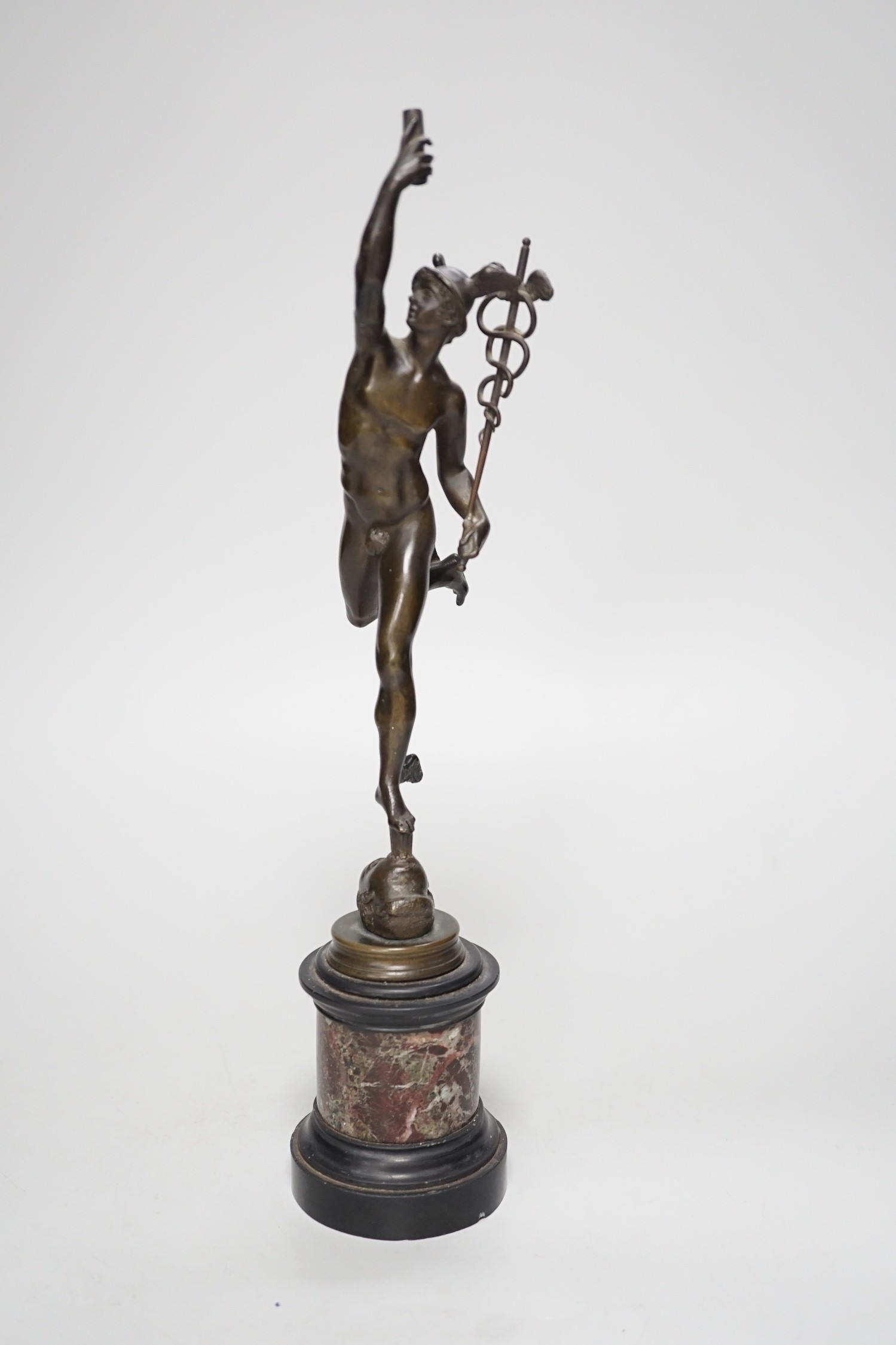 A bronze figure of Mercury on a graduated marble plinth. 33cm tall